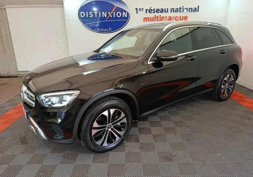Mercedes GLC 300 e Business Line noir vue 3/4 avant droit, avec jantes alliage et phares LED allumés en intérieur showroom.