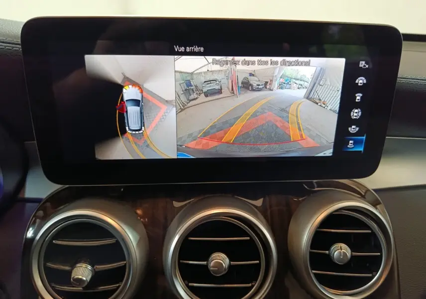 Écran tactile intérieur du Mercedes GLC 300 e Business Line montrant la caméra de recul et l'aide au stationnement.