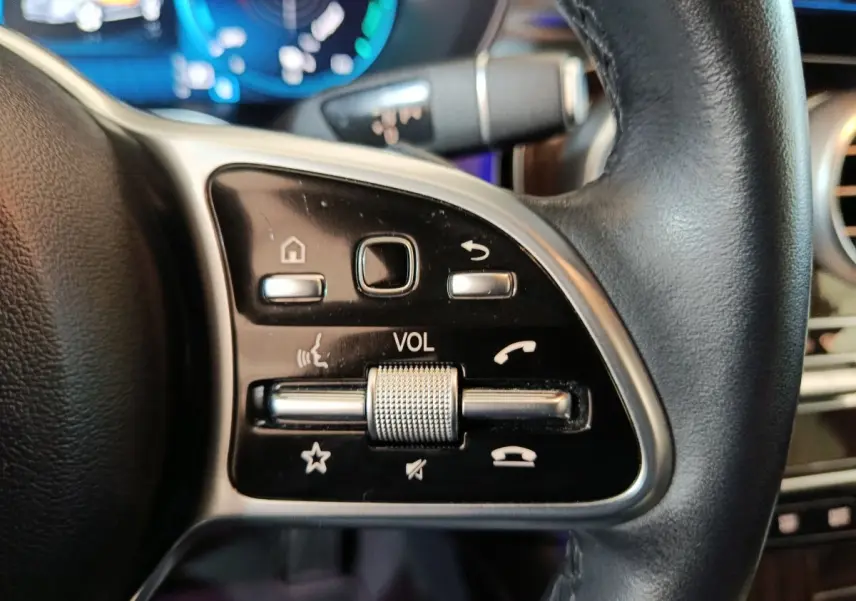 Gros plan sur les commandes noires et argentées du volant cuir du Mercedes GLC 300 e Business Line 2020.