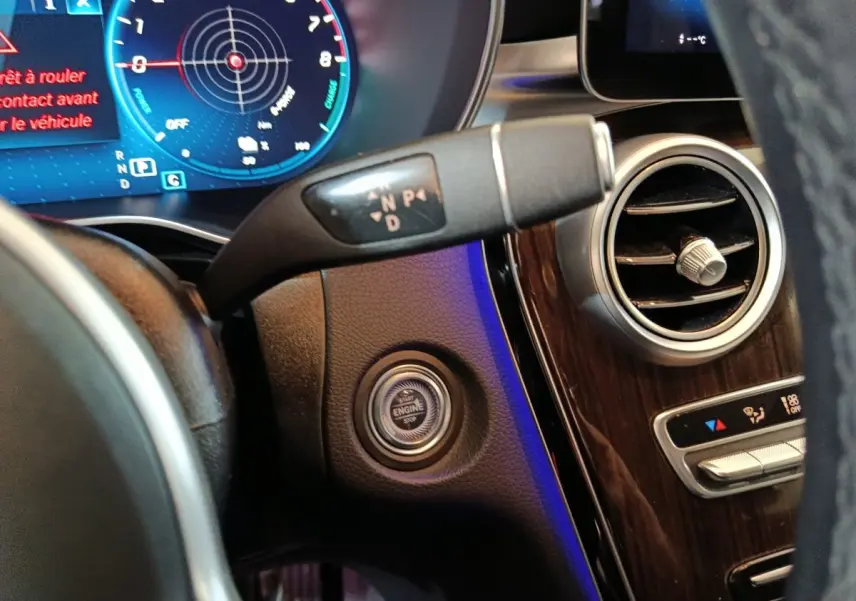 Détail du tableau de bord noir du Mercedes GLC 300 e Business Line 2020, avec bouton démarrage et levier de vitesses.