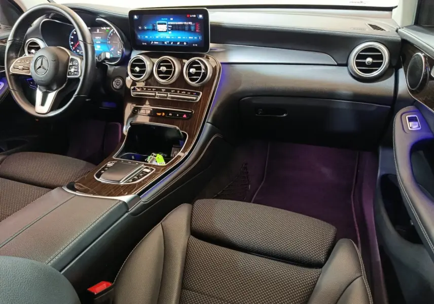 Intérieur noir de Mercedes GLC 300 e Business Line 2020 vu côté passager, avec écran tactile et finition bois.