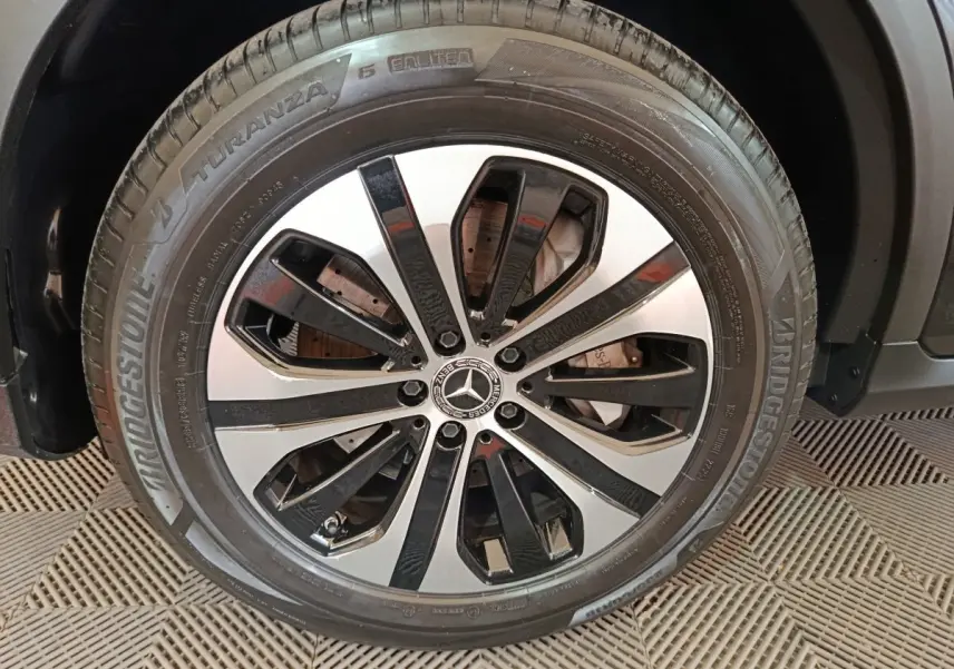 Gros plan sur la roue avant droite du Mercedes GLC 300 e noir, jante alliage bicolore et pneu Bridgestone Turanza.