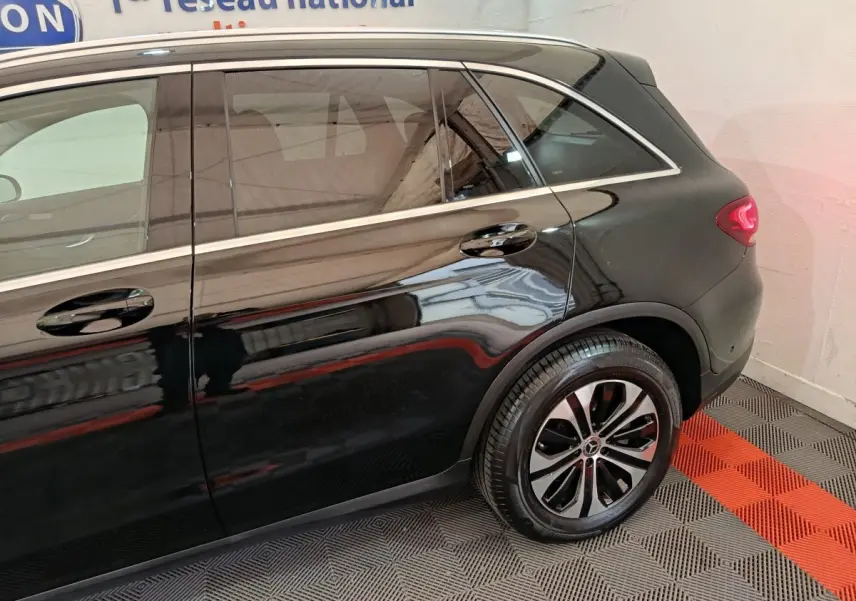 Vue latérale côté droit d'un Mercedes GLC 300 e Business Line noir, mettant en valeur la roue arrière et les lignes élégantes du SUV.