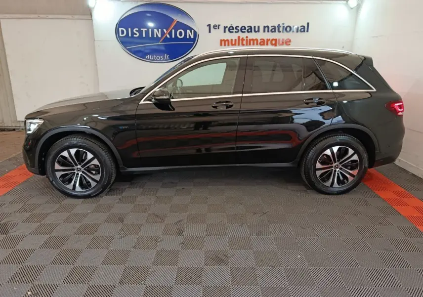 Profil côté gauche d'un Mercedes GLC 300 e Business Line hybride rechargeable noir, roues alliage et feux arrière LED visibles.