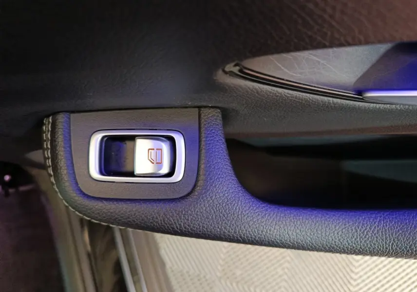 Gros plan sur le bouton de verrouillage des vitres en cuir noir à l'intérieur d'une Mercedes GLC 300 e Business Line 4Matic.