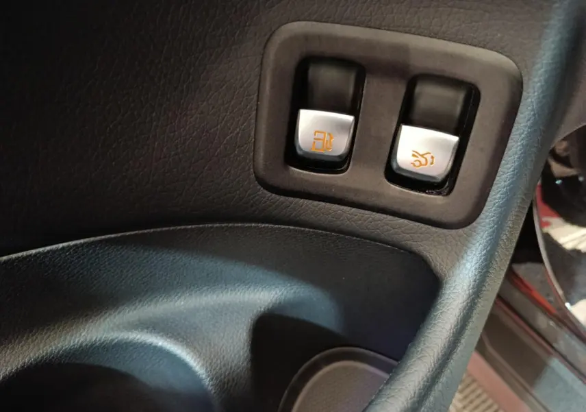 Gros plan sur les boutons d'ouverture de trappe carburant et coffre intérieur du Mercedes GLC 300 e noir de 2020.