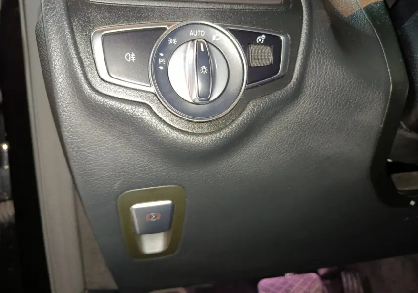 Gros plan sur le panneau de commandes d'éclairage et frein à main électrique du Mercedes GLC 300 e Business Line noir.