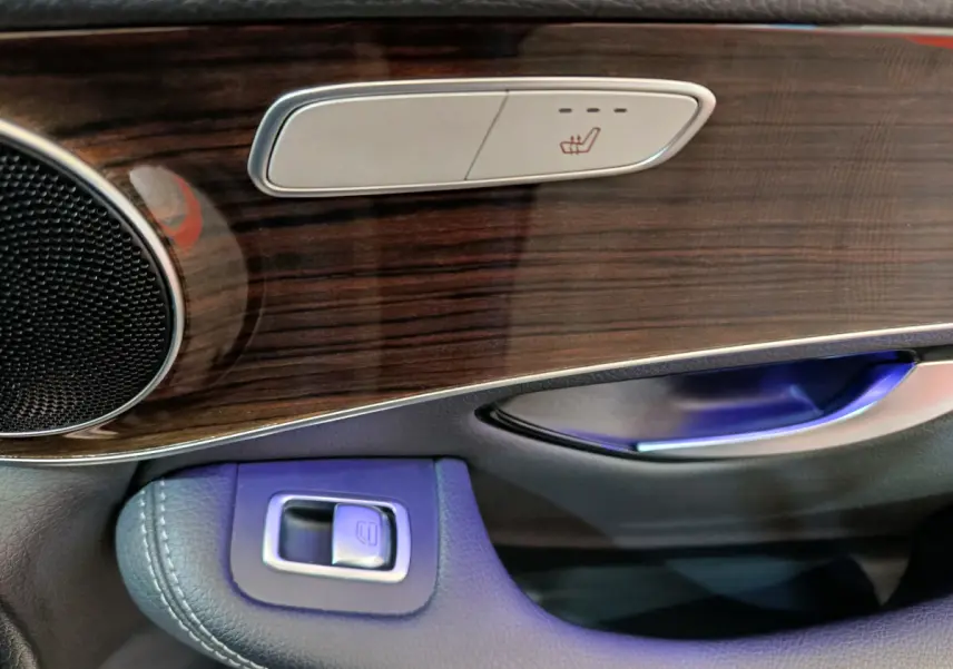 Détail de la portière côté conducteur du Mercedes GLC 300 e noir, avec bois et commandes sièges chauffants.