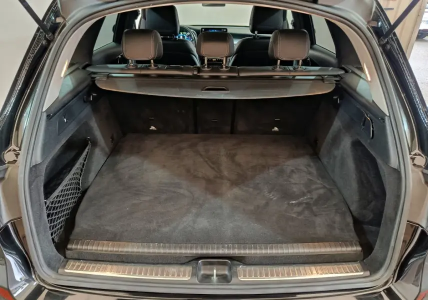 Coffre ouvert vu de l'arrière d'un Mercedes GLC 300 e Business Line noir, espace de chargement propre et spacieux.