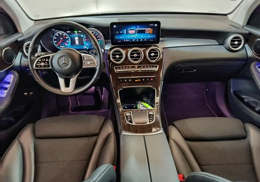 Vue intérieure avant du Mercedes GLC 300 e Business Line 2020 avec tableau de bord bois et écran tactile central lumineux.