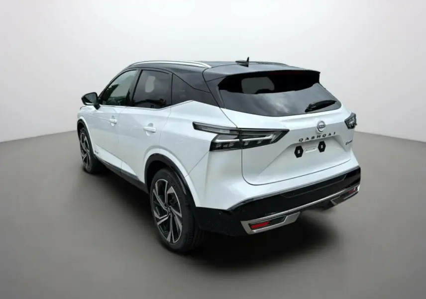 Vue 3/4 arrière droite du Nissan Qashqai blanc lunaire avec toit noir et jantes alu 20 pouces dans un studio.