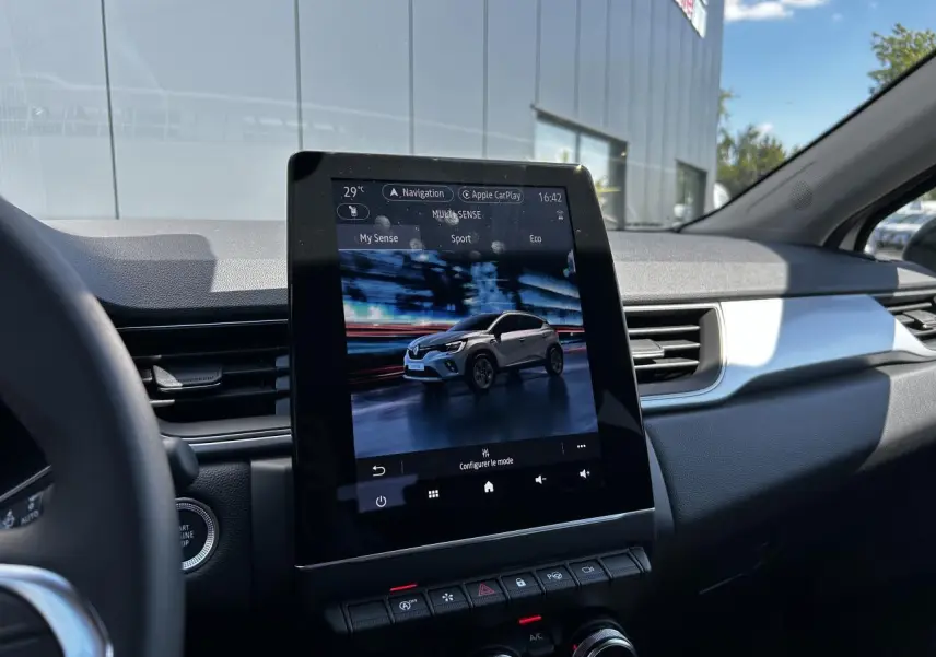 Vue intérieure centrée sur l'écran tactile 9,3'' du tableau de bord du Renault Captur gris Cassiopée 2024.