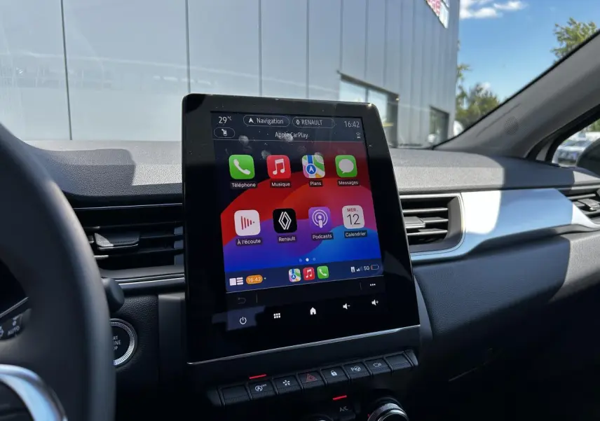 Vue intérieure du tableau de bord du Renault Captur 2024 avec écran tactile 9,3'' et interface Apple CarPlay.