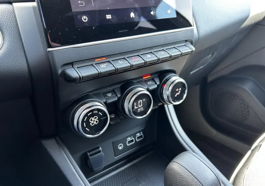 Vue rapprochée de la console centrale du Renault Captur 2024, montrant les commandes de climatisation et ports USB.