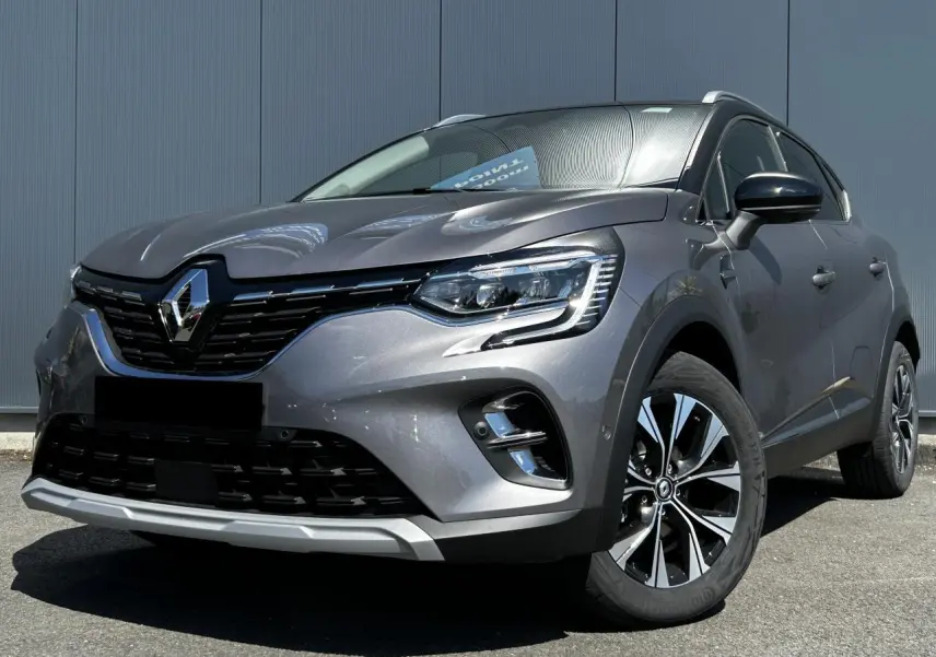 Renault Captur 2024 gris Cassiopée en 3/4 avant droit, avec jantes alliage et toit noir étoilé visible.