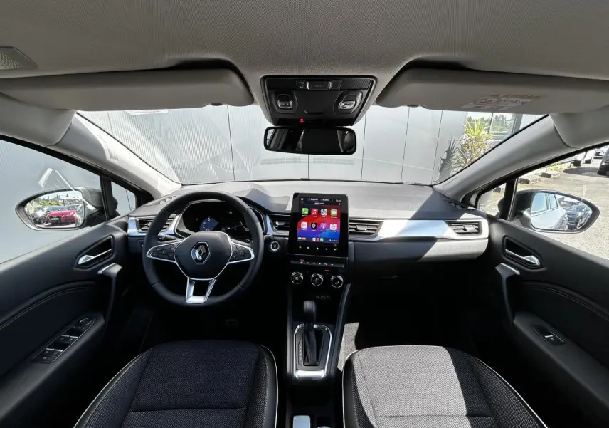 Vue intérieure avant du Renault Captur 2024 avec tableau de bord numérique et écran tactile central 9,3 pouces.
