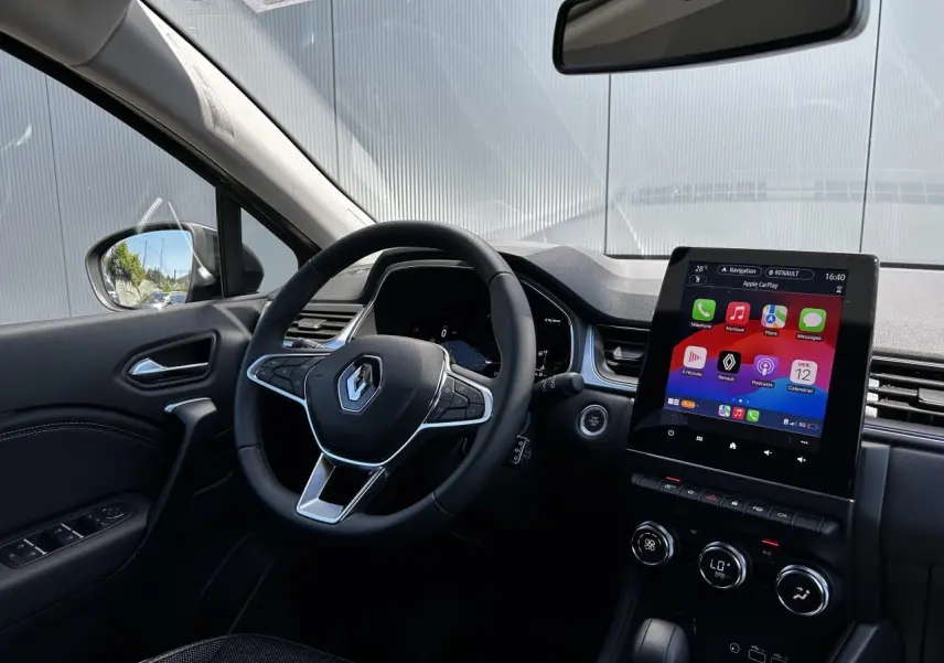 Vue intérieure côté conducteur du Renault Captur 2024 avec écran tactile 9,3'' et volant multifonction noir.