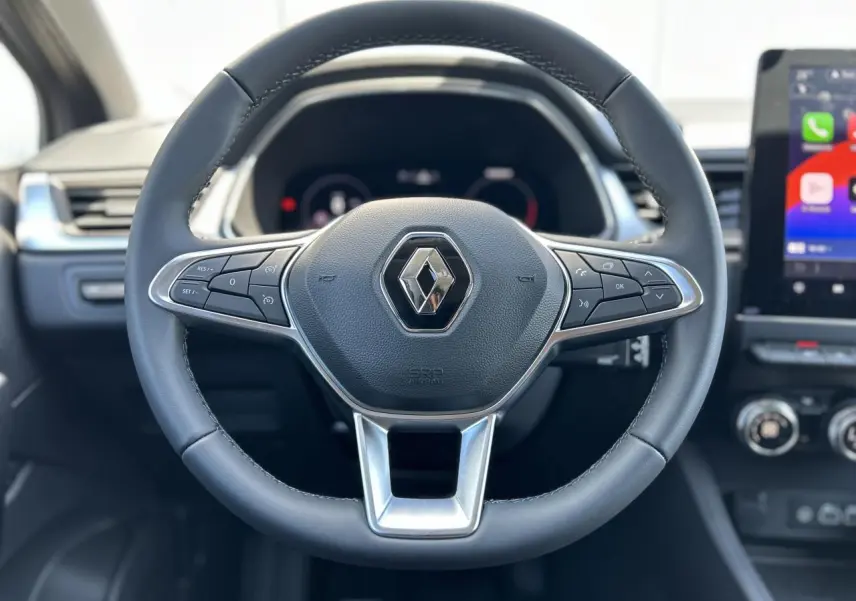Volant cuir noir avec commandes intégrées, tableau de bord numérique et écran tactile du Renault Captur 2024.