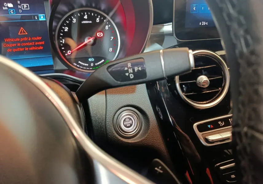 Gros plan sur le tableau de bord du Mercedes GLC 300 E bleu, avec bouton démarrage et levier de vitesses.