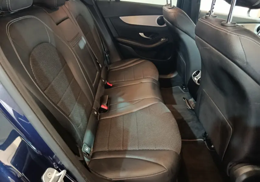 Vue intérieure côté gauche des sièges arrière en cuir noir du Mercedes GLC 300 E Business Line bleu, avec détails couture visibles.