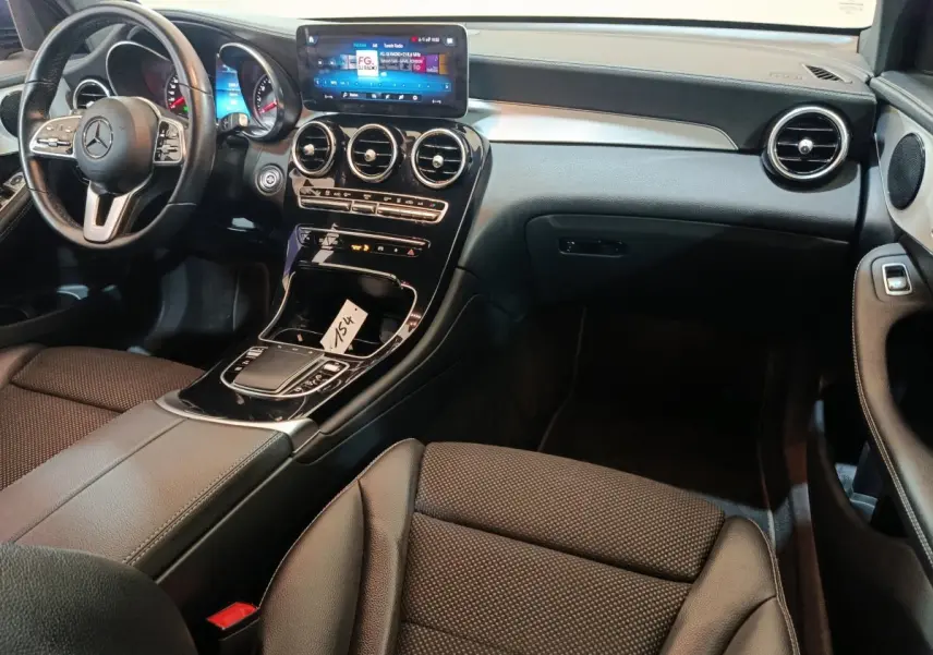 Intérieur noir du Mercedes GLC 300 E Business Line 2021 vu côté passager, avec écran tactile central et volant cuir.