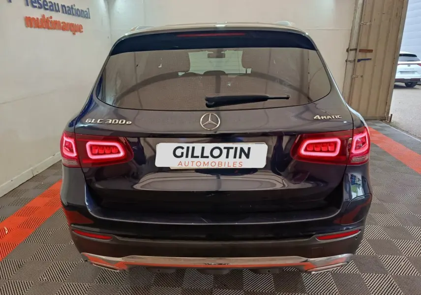 Vue arrière d'un Mercedes GLC 300e bleu avec feux LED allumés et logo 4MATIC visible sur le hayon.