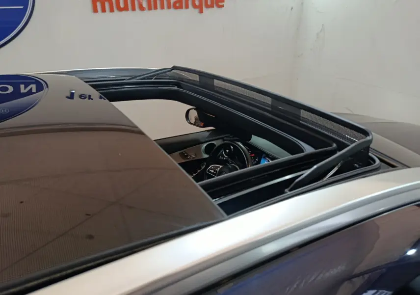 Vue rapprochée du toit ouvrant panoramique ouvert d’un Mercedes GLC bleu, dévoilant l’intérieur côté conducteur.