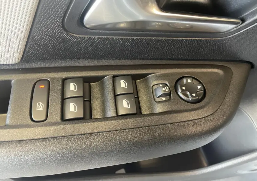 Détail des commandes de lève-vitres et réglage des rétroviseurs sur la porte côté conducteur de la Citroën C4 blanche.