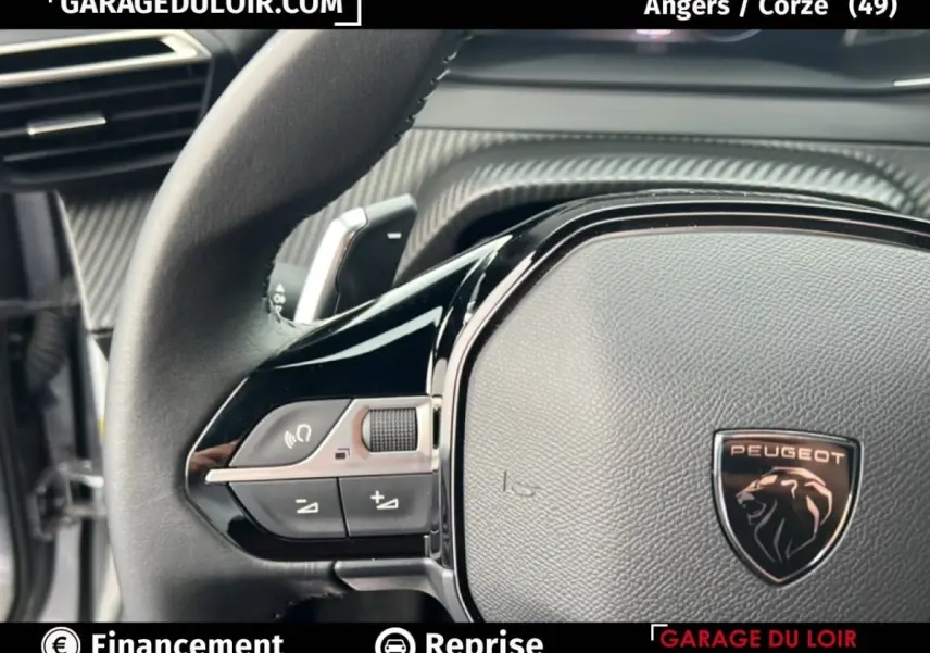 Gros plan sur le volant noir du Peugeot 2008 Hybrid 136 e-DCS6 Allure 2025 avec logo lion et commandes intégrées.