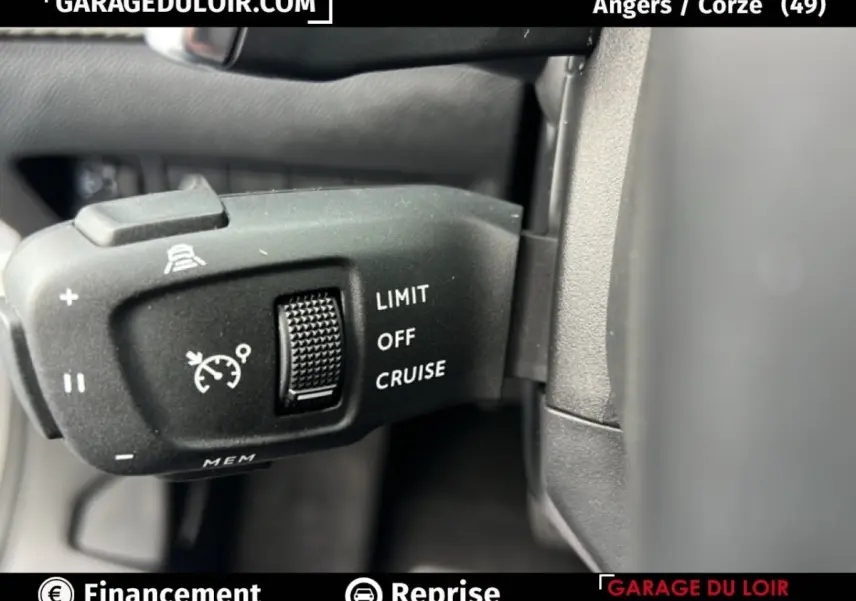 Gros plan sur la commande de régulateur de vitesse du Peugeot 2008 Hybrid gris clair, intérieur côté gauche.