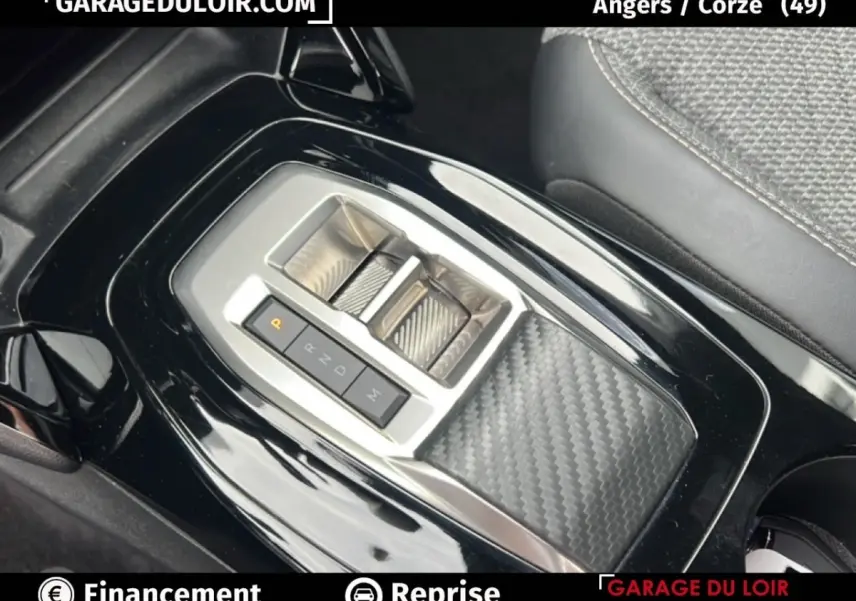 Gros plan sur la console centrale noire brillante du Peugeot 2008 Hybrid 136 e-DCS6 Allure avec levier de vitesses moderne.