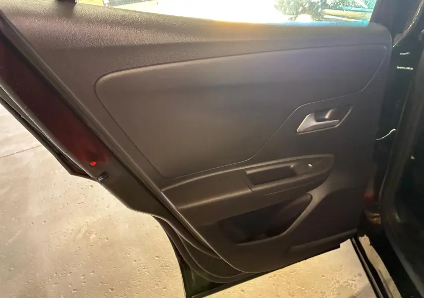 Intérieur de la porte arrière gauche noire de l’Opel Mokka 1.2 Turbo 145 Edition 2025, avec poignée argentée et commande de vitre.