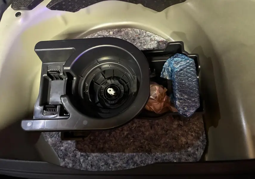Vue rapprochée du coffre de l’Opel Mokka 2025 montrant le rangement sous plancher avec outils emballés.