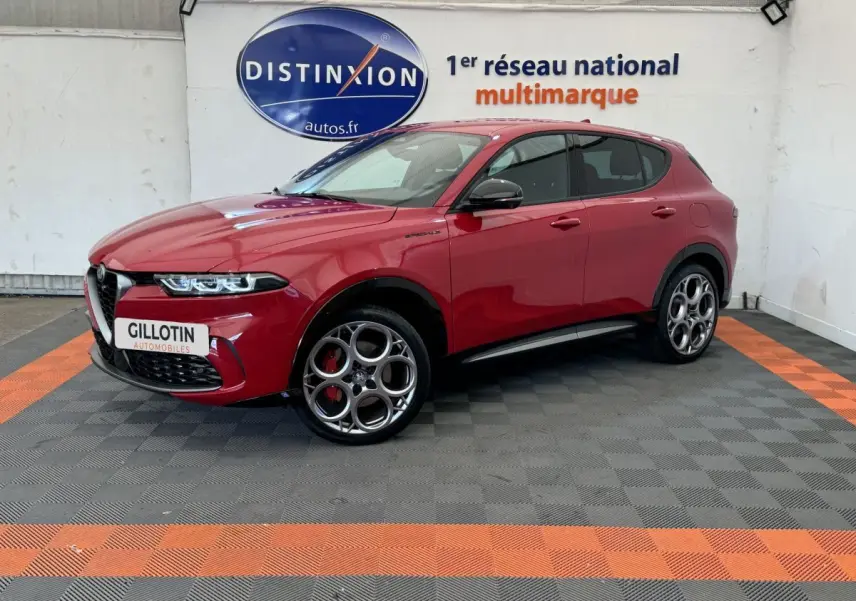 Alfa Romeo Tonale rouge en 3/4 avant droit, avec jantes spécifiques et calandre caractéristique visible en showroom.