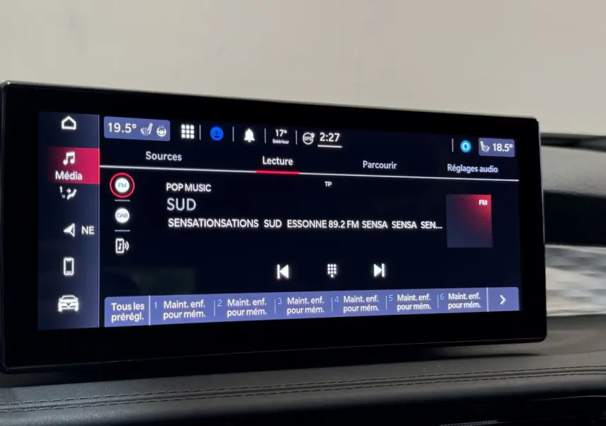 Écran tactile central affichant la radio FM dans l'habitacle de l'Alfa Romeo Tonale rouge, vue intérieure rapprochée.