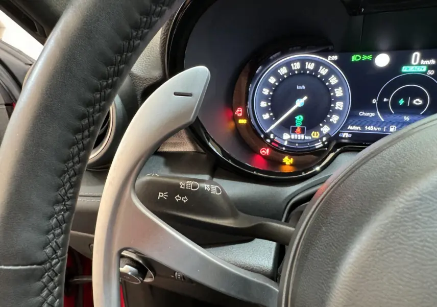 Vue rapprochée du tableau de bord et volant de l'Alfa Romeo Tonale rouge, affichage digital et commandes au volant visibles.