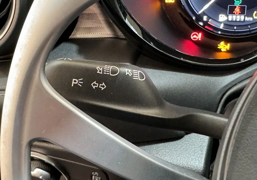 Gros plan sur la manette de clignotant noire dans l'habitacle de l'Alfa Romeo Tonale 2023 rouge hybride rechargeable.