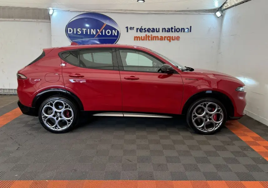 Profil droit de l'Alfa Romeo Tonale rouge 2023 avec jantes distinctives et détails noirs contrastants.