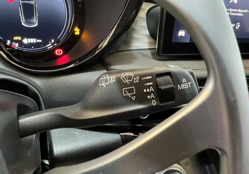 Gros plan sur la commande d’essuie-glace à gauche du volant dans l’habitacle de l’Alfa Romeo Tonale rouge 2023.