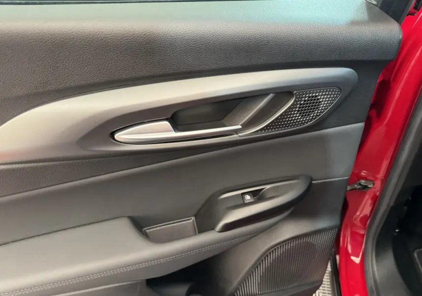 Gros plan sur la porte côté conducteur noire avec poignée alu et cadre rouge vif visible sur une Alfa Romeo Tonale 2023.