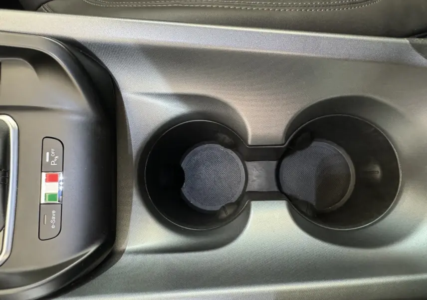 Gros plan sur la console centrale noire avec porte-gobelets et boutons e-Save et parking de l'Alfa Romeo Tonale rouge 2023.