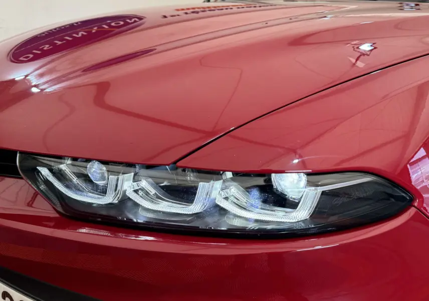 Gros plan sur le phare avant gauche LED de l'Alfa Romeo Tonale rouge 2023, soulignant son design distinctif.