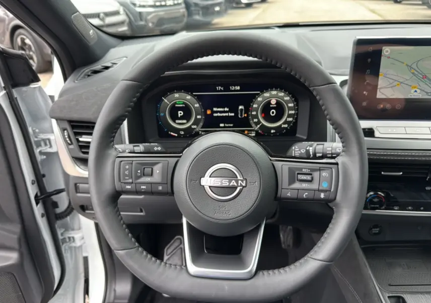 Vue intérieure centrée sur le volant cuir multifonctions du Nissan Qashqai E-POWER 205 Tekna Plus blanc lunaire.