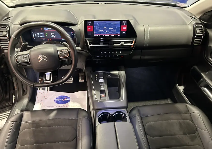 Vue intérieure avant du Citroën C5 Aircross 2023, tableau de bord noir avec écran tactile GPS et volant multifonction.