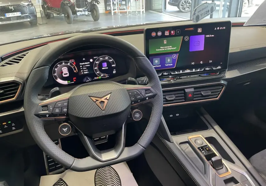 Vue intérieure centrée sur le volant CUPRA en cuir noir avec logo cuivré et écran tactile HD du tableau de bord.