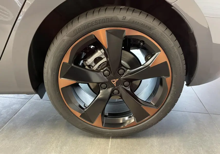 Gros plan sur la jante alliage 18'' cuivrée et noire de la CUPRA Leon gris, avec logo Cupra central visible.