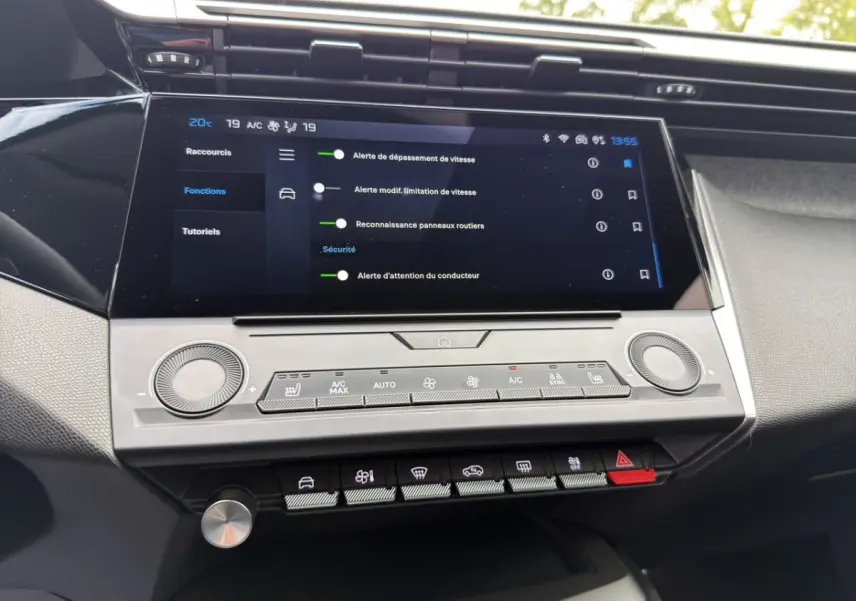 Vue rapprochée de l'écran tactile central et des commandes de climatisation de la Peugeot 308 Hybrid 145 e-DCS6 Allure 2025.