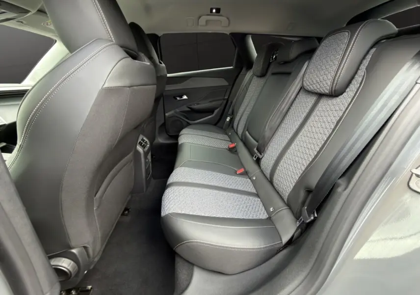 Vue intérieure arrière côté droit des sièges arrière en tissu et cuir gris de la Peugeot 308 Hybrid 145 e-DCS6 Allure 2025.