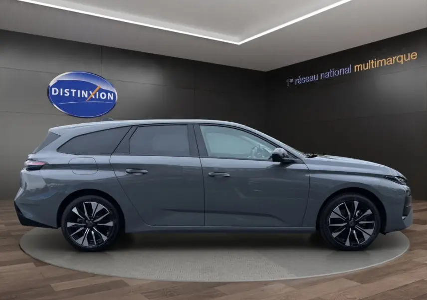 Peugeot 308 Hybrid gris foncé vue de profil côté gauche, avec jantes alliage noires et toit légèrement incliné.