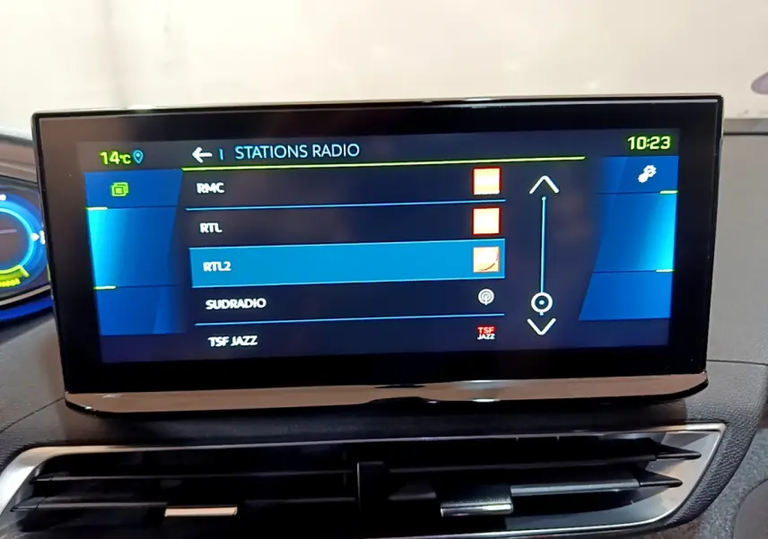 Écran tactile central du tableau de bord du Peugeot 3008 bleu, affichant la liste des stations radio.